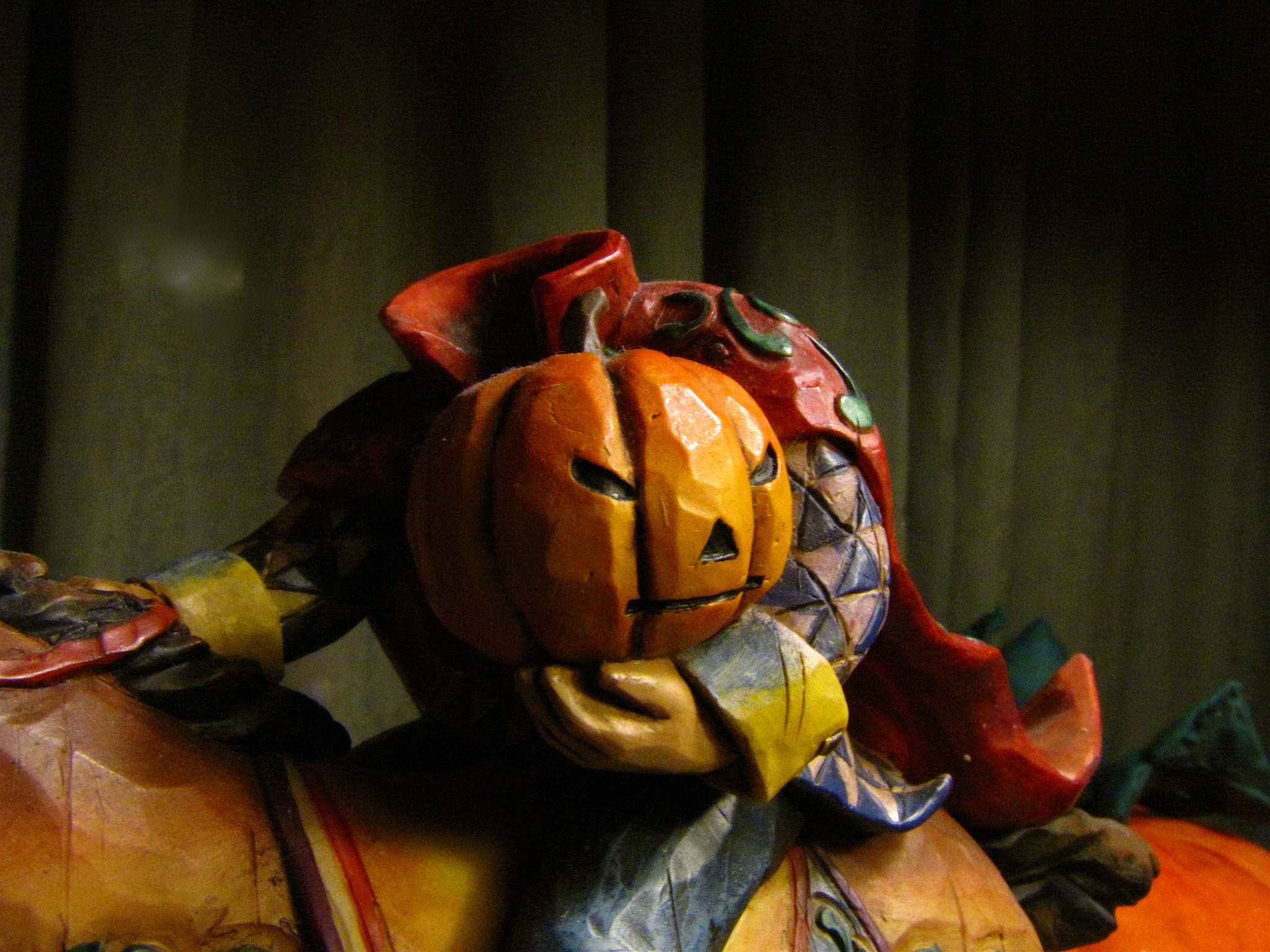 A headless horseman made of ceramic, holding a pumpkin at his side as he rides a horse